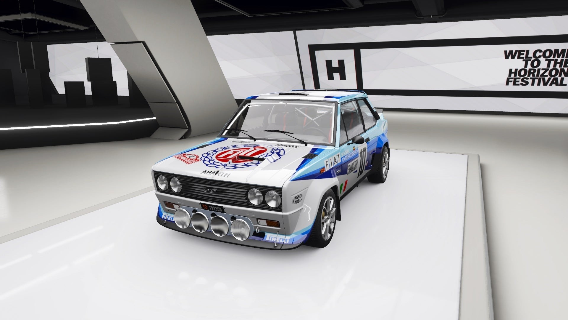 Abarth 131 màu đỏ trắng đang đua trên đường đất trong Forza Horizon 4