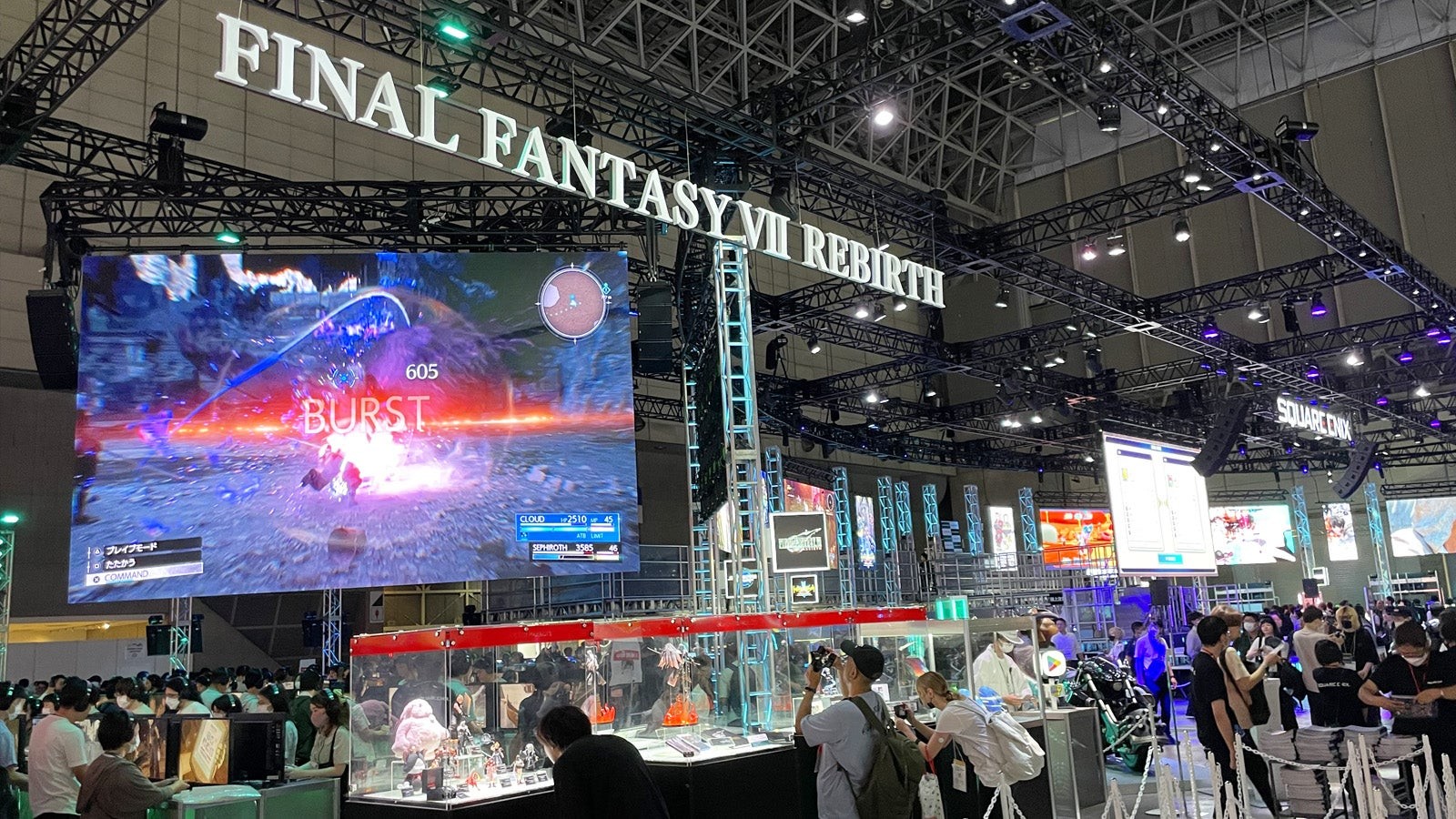 Gian hàng Final Fantasy tại Tokyo Game Show với màn hình lớn và các sản phẩm trong tủ kính