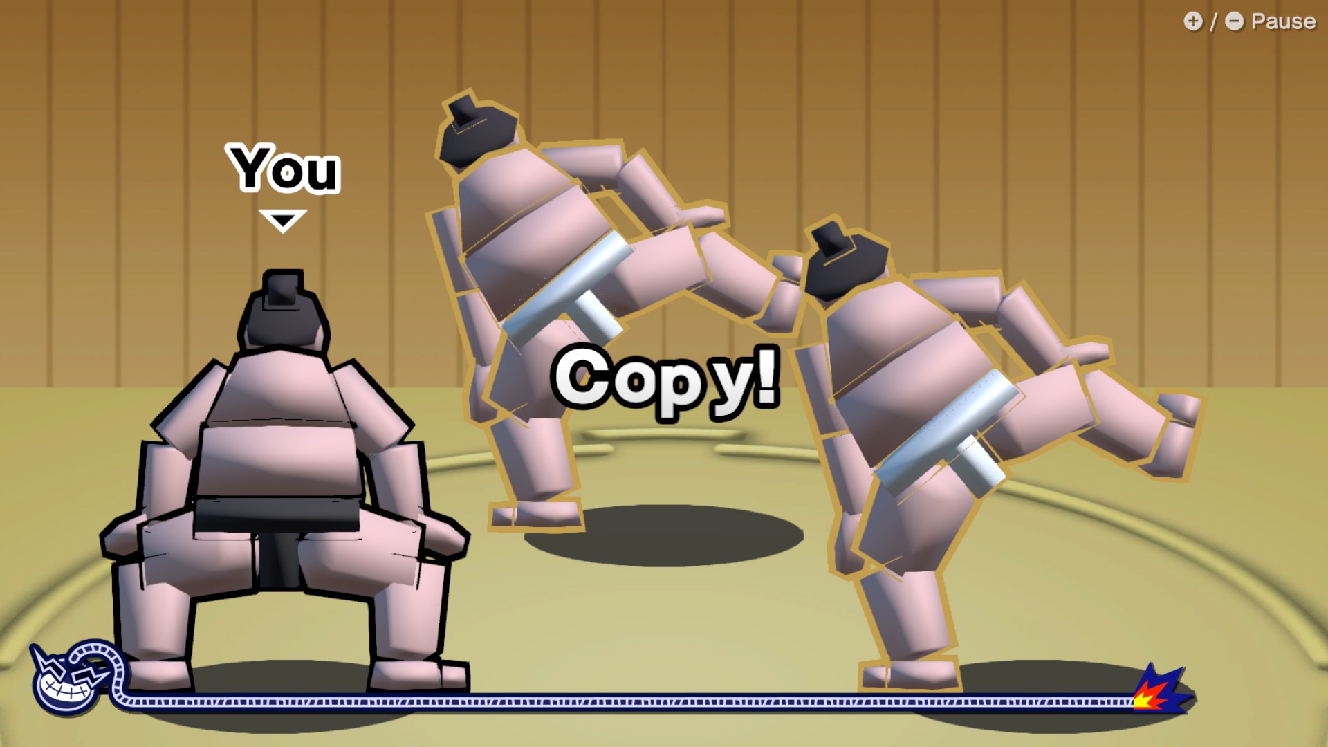 Một ảnh chụp màn hình từ WarioWare: Move It! cho thấy ba đô vật sumo. Hai người có chân nâng lên như chó sắp tè vào cột đèn. Người thứ ba phải bắt chước họ.